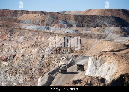 Enormi camion trasportano minerali d'oro dalla miniera a cielo aperto alla lavorazione presso Cripple Creek e Victor Gold Mine, a Victor, Colorado. Foto Stock