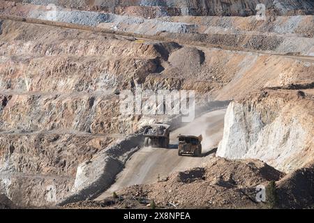 Enormi camion trasportano minerali d'oro dalla miniera a cielo aperto alla lavorazione presso Cripple Creek e Victor Gold Mine, a Victor, Colorado. Foto Stock