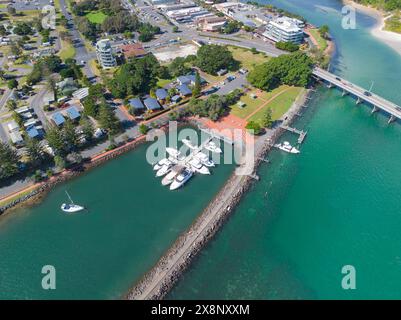 Vista aerea delle barche in un porticciolo riparato da frangiflutti rocciosi sul fiume costiero di Fortser, sulla costa settentrionale del nuovo Galles del Sud in Australia Foto Stock