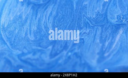 Versare l'inchiostro. Turbolenza glitter. Onde brillanti astratte blu macchie bianche particelle scintillanti sfondo testurizzato sfocato spazio vuoto. Foto Stock