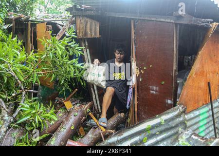 Laguna, Calabarzon, Filippine. 26 maggio 2024: Filippino evacuare la sua casa in cui il tronco dell'albero è caduto a 1 m dalla culla del bambino. Previsione come grave depressione tropicale, la prima tempesta che ha colpito l'arcipelago quest'anno Aghon (Ewiniar) ha sorpreso i filippini per intensità devastante: Inondazioni, distruzioni, interruzioni di corrente/acqua previste per giorni, cadute di alberi, centinaia di soccorsi e famiglie nei centri di evacuazione. Riclassificato come tifone, gov ha annunciato aiuti umanitari. In poche ore, il paese è passato da record di caldo di mesi e siccità estrema a piogge torrenziali e inondazioni. Crediti: Kevin Izorce/Alamy Live News Foto Stock