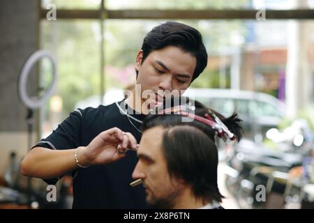 Uomo che viene tagliato di capelli in barbiere Foto Stock