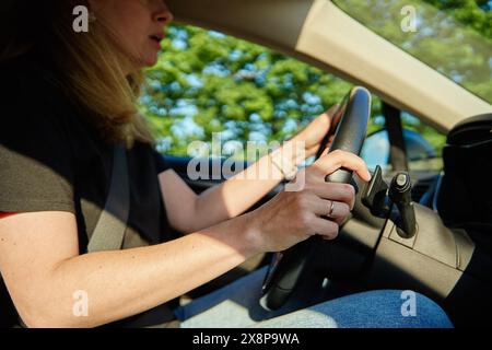 Donna che guida un'auto sulla strada di campagna al tramonto. Pilota donna nel veicolo Foto Stock
