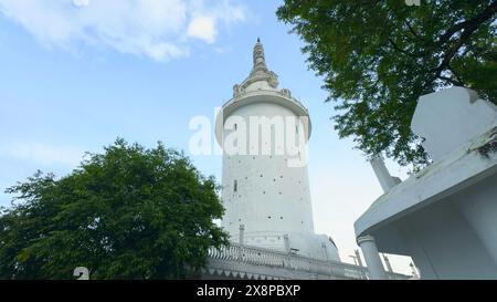 Sri Lanka, Kandy - 29 luglio 2023: White Tower in Sri Lanka. Azione. Vista dal basso ai piedi della torre bianca di ambuluvava. Torre bianca vorticosa con Foto Stock