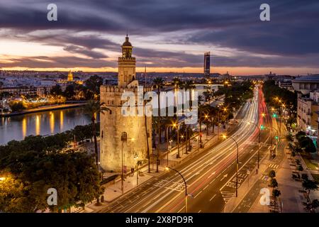 Vista notturna del fiume Guadalquivir a Siviglia con i ponti Barqueta e Alamillo, illuminati al tramonto Foto Stock