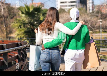 due amici che camminano in un parco con le borse della spesa Foto Stock