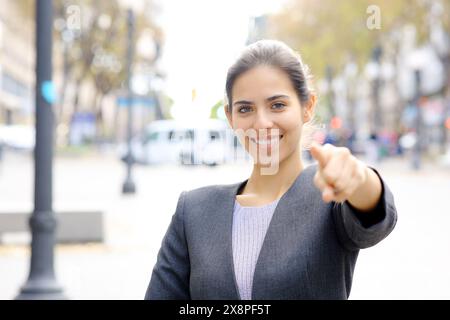 Giovane dirigente felice che ti indica per strada Foto Stock