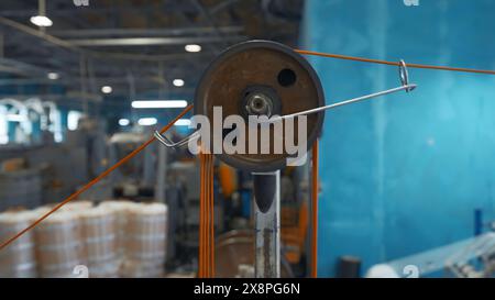 Macchina industriale con bobine rotanti e filo. Creatività. Sistema con bobine di fili di tensionamento su macchine industriali. Macchine industriali con fili Foto Stock
