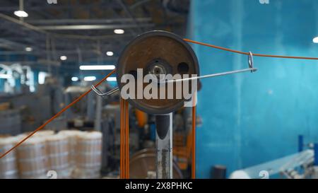 Macchina industriale con bobine rotanti e filo. Creatività. Sistema con bobine di fili di tensionamento su macchine industriali. Macchine industriali con fili Foto Stock