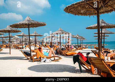 Sir Bani Yas, Emirati Arabi Uniti - 5 gennaio 2024: Un tranquillo paesaggio marino con i visitatori che si rilassano sotto il sole arabo. Foto Stock