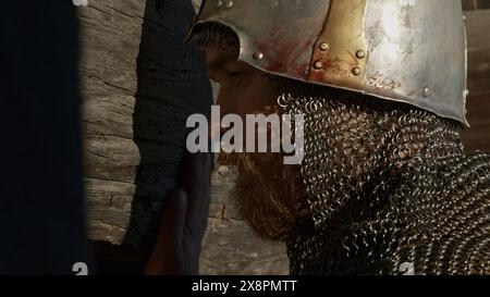 Vecchio casco da cavaliere medievale e posta a catena per protezione in battaglia. Supporto. Vista laterale ravvicinata di un uomo con un copricapo molto pesante, armatura del Medioevo Foto Stock