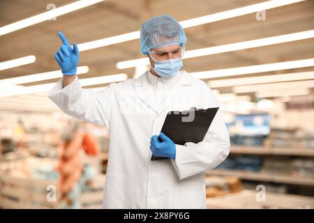 Specialista del controllo della qualità alimentare che esamina i prodotti nei supermercati Foto Stock