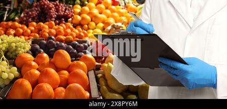 Specialista del controllo della qualità alimentare che esamina la frutta al mercato, primo piano. Design banner Foto Stock