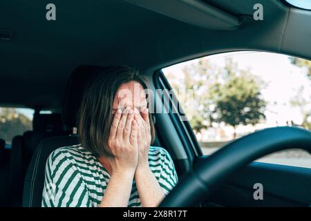 Una donna triste delusa che piange in auto, concentrazione selettiva Foto Stock