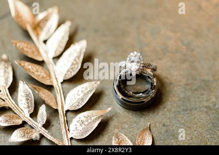 Fedi nuziali e foglie d'argento su pietra Foto Stock