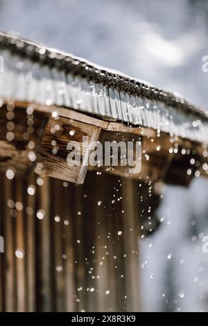 Sciogliere la neve che gocciola dal tetto nella zona sciistica di KitzbÃ¼hel Foto Stock