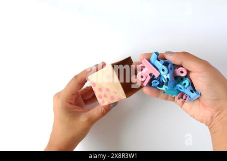 Organizzazione creativa: Clip di legatura colorate nella scatola Origami di carta Foto Stock