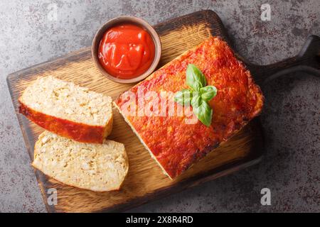 Polpettone di pollo a fette servito con un primo piano del ketchup sul tavolo di legno. Vista dall'alto orizzontale Foto Stock