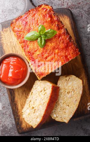 Terrina di carne di pollo o polpettone serviti con il ketchup sul tavolo. Vista dall'alto verticale Foto Stock