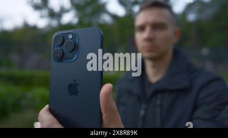 Regno Unito, Londra - 15 settembre 2023: L'uomo scatta foto su iPhone 15. Azione. Primo piano del logo Apple sul nuovo iPhone 15 pro nelle mani dell'uomo. L'uomo spara Foto Stock