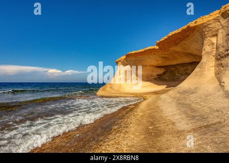 La gemma nascosta di Gozo, la spiaggia di ciottoli della baia di Xwejni con acque turchesi invitano a trascorrere una giornata rilassante a Gozo, Malta. Foto Stock