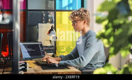 Vista laterale delle linee di codice scritte da un tirocinante maschile di Data Science su un computer desktop in Stylish Office. Giovane uomo caucasico risolvere problemi software per Big Tech Company. Fututre Programmer impara a codificare. Foto Stock