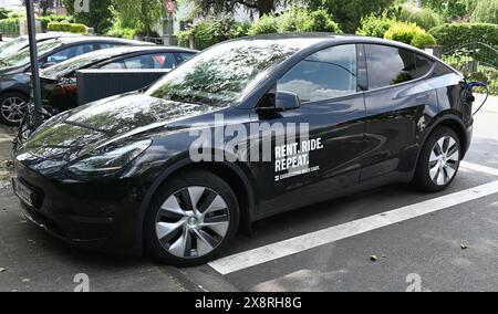 Colonia, Germania. 20 maggio 2024. Una Tesla dell'azienda di car sharing Miles è parcheggiata presso una stazione di ricarica sul lato della strada e viene addebitata l'accredito: Horst Galuschka/dpa/Alamy Live News Foto Stock