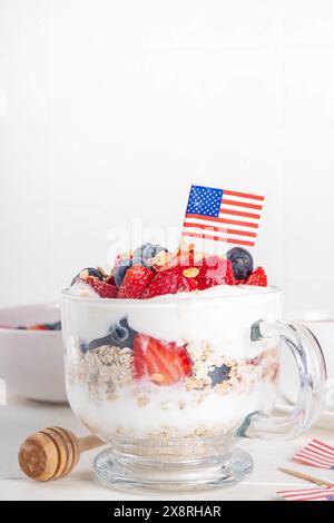 Colazione patriottica o brunch negli Stati Uniti semplice idea di ricetta, dessert alla muesola a strati o farinata d'avena per la notte in vetro decorata con yogurt bianco montato, blu Foto Stock