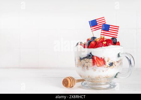 Colazione patriottica o brunch negli Stati Uniti semplice idea di ricetta, dessert alla muesola a strati o farinata d'avena per la notte in vetro decorata con yogurt bianco montato, blu Foto Stock