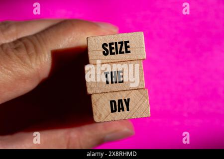 Cogli le parole del giorno scritte su blocchi di legno con sfondo rosa. Cattura il simbolo del giorno concettuale. Copia spazio. Foto Stock