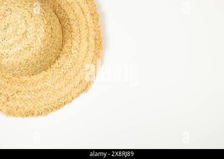 Vista dall'alto del cappello di paglia su sfondo bianco. Moda estiva, vacanze e carta da parati da spiaggia. Copia spazio, disposizione piatta. Foto Stock