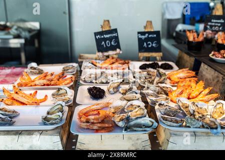 Ostriche fresche, gamberi e ricci di mare viola in un negozio di pesce gourmet al mercato di Bolhao, al mercato del cibo di strada a Porto o Oporto, Portogallo Foto Stock