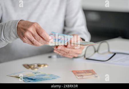 Le mani delle donne anziane contano i soldi, euro, in vista ravvicinata Foto Stock