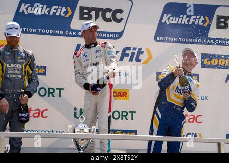 Colin Turkington con Josh Cook e Ash Sutton spruzzano champagne Round 4 Brands Hatch Indy durante il BTCC British Touring Car Championship a Brands ha Foto Stock