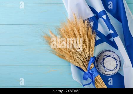 Storia ebraica Shavuot. Bouquet maturo di grano con nastro blu con bandiera israeliana e sfondi. Simboli del concetto Shavuot festivo ebraico. Indietro Foto Stock