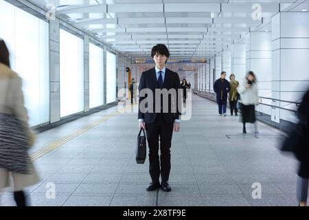 Uomo giapponese in tuta in piedi in un corridoio vuoto Foto Stock