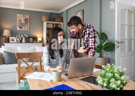 Giovane coppia, liberi professionisti titolari di piccole imprese su Internet, designer professionisti, sviluppatori di software informatici, che lavorano insieme a casa, sul nuovo progetto Foto Stock