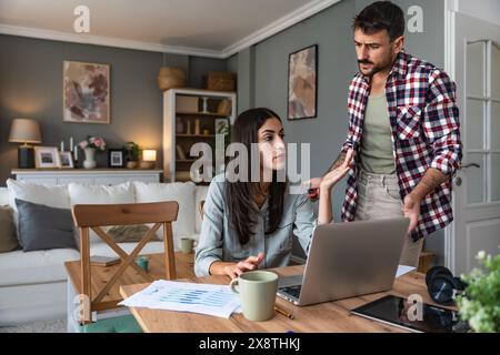 Giovane coppia, liberi professionisti titolari di piccole imprese su Internet, designer professionisti, sviluppatori di software informatici, che lavorano insieme a casa, sul nuovo progetto Foto Stock