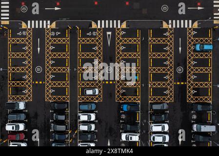 Vista aerea direttamente sopra un ampio parcheggio con posti auto per conducenti disabili o disabili Foto Stock