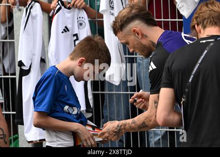 Jena, Germania. 27 maggio 2024. Calcio: Squadra nazionale, preparazione ai campionati europei di casa, sessione pubblica di allenamento per la squadra DFB presso il campo sportivo Ernst Abbe. David Raum firma autografi per i fan. Crediti: Federico Gambarini/dpa/Alamy Live News Foto Stock