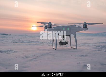 Khuzhir, Russia - 1 marzo 2021: Drone DJI Phantom 4 PRO sul lago coperto di neve baikal al al tramonto durante l'inverno. Foto Stock