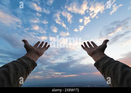 L'uomo alzò le mani sopra la testa per chiedere misericordia a Dio in conformità con la sua fede in Dio nel cristianesimo. uomo che alza entrambe le mani per chiedere Foto Stock
