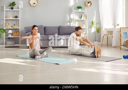 Coppia di famiglie che si allenano a casa Foto Stock