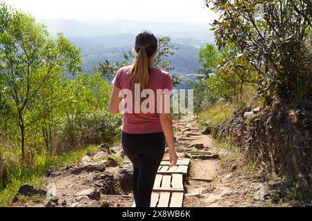 Jaragua State Park, San Paolo, Brasile. Una giovane escursionista cammina sul sentiero Trilha do Pai Ze sul picco Jaragua a San Paolo, Brasile. Foto Stock