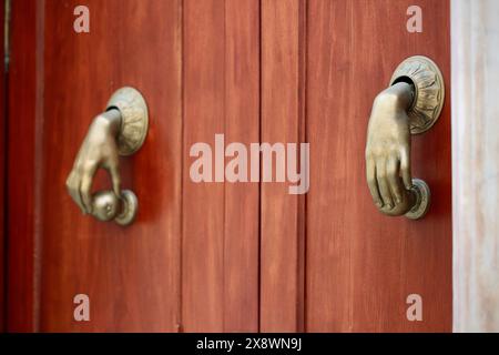 Un paio di tradizionali battitori di porte in ottone a forma di mano che tiene una mela - si dice che allontanino gli spiriti maligni, Cadice, Spagna Foto Stock