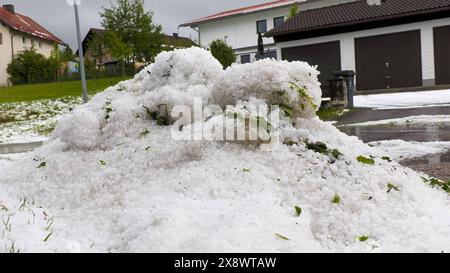 Schwere Unwetter mit jede Menge Hagel ziehen seit den Abendstunden durch Südbayern. Betroffen vor allem die alpennahen Gebiete. Eine Superzelle zog von Füssen quer nach Garmisch-Partenkirchen. Im Gepäck kein Schnee sondern regelrechte Hagelmassen. Besonders heftig traf es die Ortschaft Ried am Forggensee. Ein Radlader War im Einsatz, um den Hagel von der Straße zu beseitigen. Eine Radfahrerin wurde völlig vom Hagel und den Massen überrascht. ICH konnte mich noch unter einer Plane unterstellen, dann fing es an zu Hageln. Man könnte jetzt Ski fahren, erzählt sie. Der Hagel türmt sich auch auf de Foto Stock