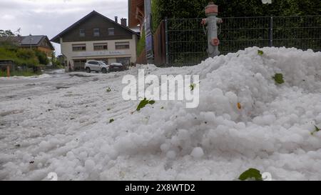 Schwere Unwetter mit jede Menge Hagel ziehen seit den Abendstunden durch Südbayern. Betroffen vor allem die alpennahen Gebiete. Eine Superzelle zog von Füssen quer nach Garmisch-Partenkirchen. Im Gepäck kein Schnee sondern regelrechte Hagelmassen. Besonders heftig traf es die Ortschaft Ried am Forggensee. Ein Radlader War im Einsatz, um den Hagel von der Straße zu beseitigen. Eine Radfahrerin wurde völlig vom Hagel und den Massen überrascht. ICH konnte mich noch unter einer Plane unterstellen, dann fing es an zu Hageln. Man könnte jetzt Ski fahren, erzählt sie. Der Hagel türmt sich auch auf de Foto Stock