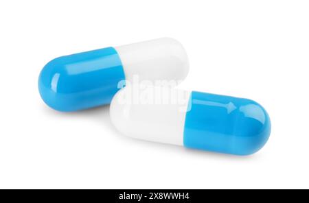 Due pillole antibiotiche isolate su bianco. Trattamento medico Foto Stock