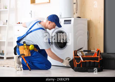 Tecnico di servizio di riparazione della lavatrice in bagno Foto Stock