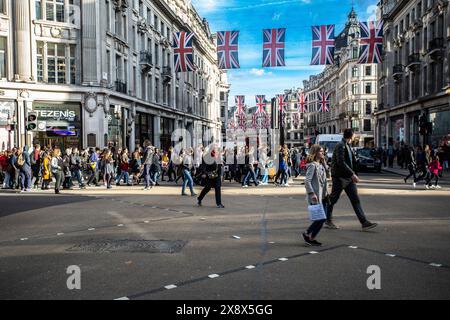 I pedoni di Regent Street all'incrocio diagonale di Oxford Circus, Londra, Regno Unito Foto Stock